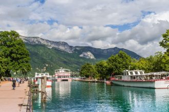 Le lac d'Annecy et ses bateaux de croisiere, avec les montagnes en arriere-plan